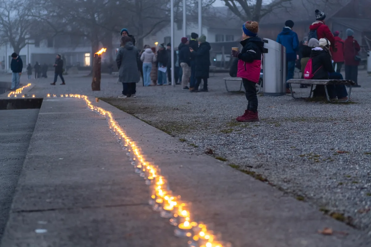 Eine lange Linie aus Kerzen am Pfäffiker Seequai. Ein Junge steht davor.